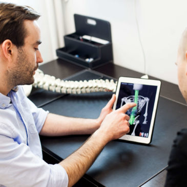 osteopata omawia terapię manualną kręgosłupa w gabinecie w Warszawie
